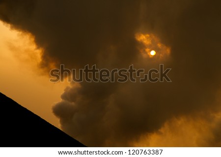 smoking volcano at sunset