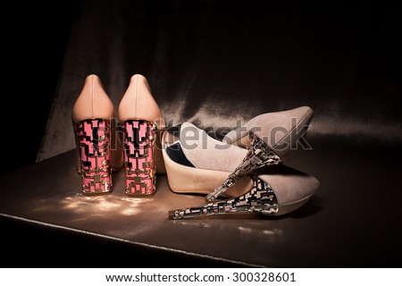Two pairs glamour high heeled shoes on gold silk
