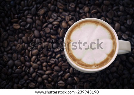 Closeup of a beautiful cup of hot coffee on coffee bean background
