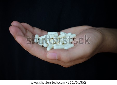 picture of hands holding white pack and pills