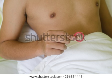 A man on bed show condom