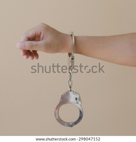 hand in shackle on brown background