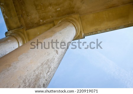 unusual angle of view  from below to the pillars and roof of abandoned manor
