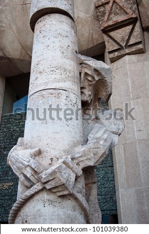Statue of Jesus and a stone pillar by Gaudi at Sagrada Familia. Barcelona, Spain.