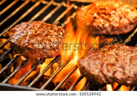 Photograph of three tasty beef burgers on the grill