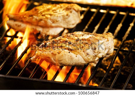 Photograph of two chicken fillets on the barbecue