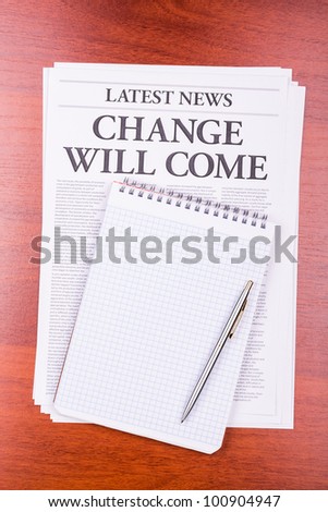 The newspaper LATEST NEWS with the headline CHANGE WILL COME and notepad