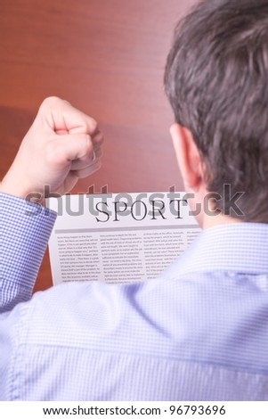 Man reading a newspaper with inscription SPORT