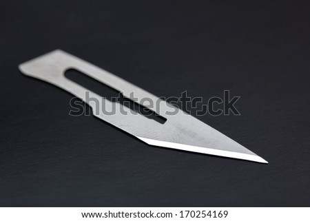 A close up of a single scalpel blade