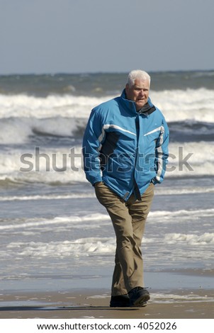 a male senior walking on the beach