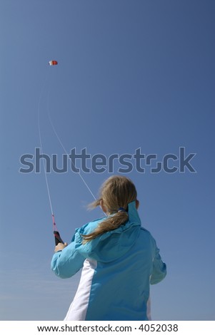 a sporty girl flying kites at the beach