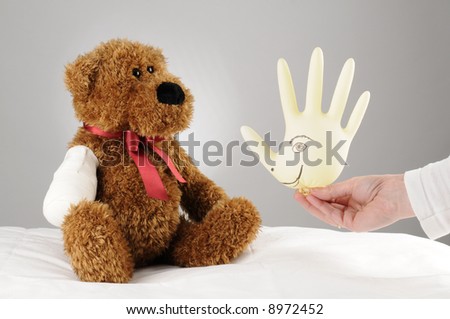 a pediatrician trying to cheer up an injured teddy bear a hospital balloon