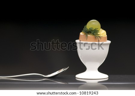 stock-photo-close-up-of-a-deviled-egg-topped-with-grape-and-dill-against-black-background-10819243.jpg