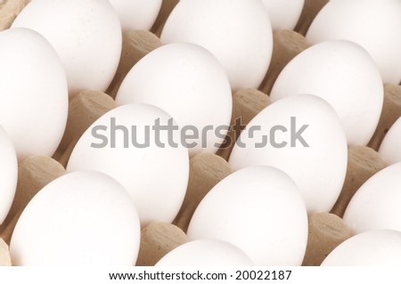 a cardboard tray filled with white eggs