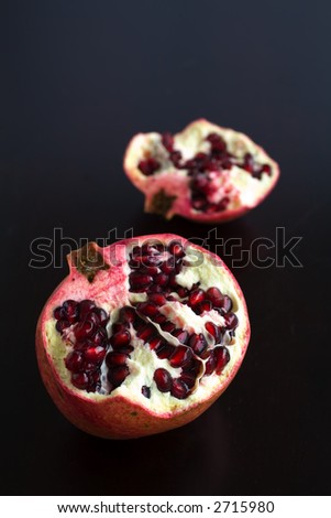 pomegranates cut open with pomegrante seeds showing