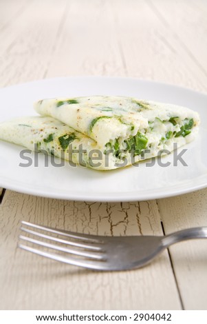 Egg white and spinach omelet on a white plate - stock photo
