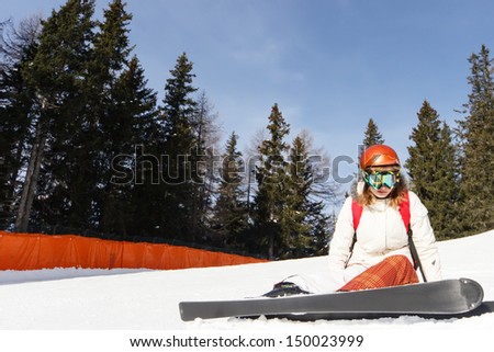 Teenager learning how to ski in the blue sky ant mountains background
