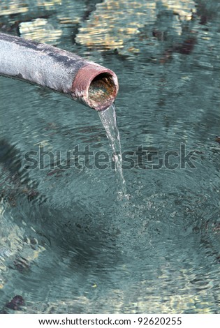 Fresh crystal clear drinking water pouring out from tube. Very detailed.