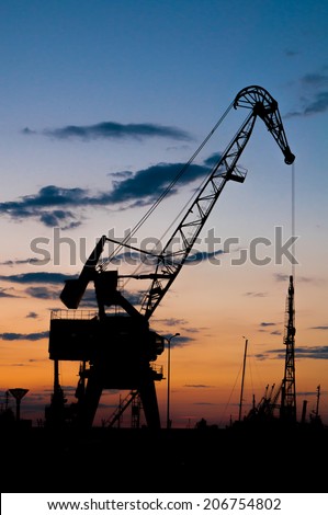 Silhouette of crane in port. Sunset.