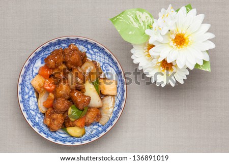 sweet and sour pork and white artificial flowers