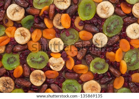 Dried apricots, kiwi, figs, dates, cranberries on sackcloth can use as background as a background