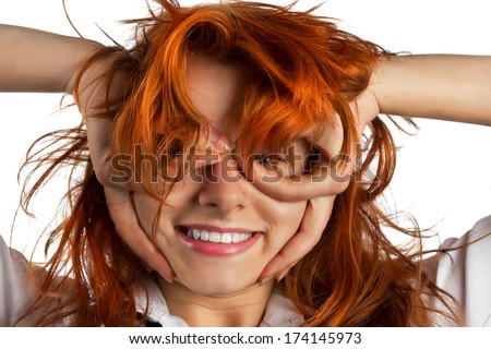 Red-haired girl makes out of its hands symbolic glasses, isolated on white background