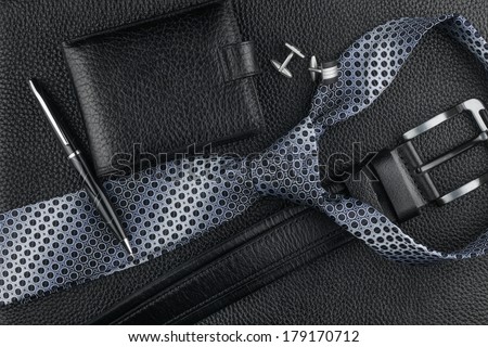Tie, belt, wallet, cufflinks, pen lying on the skin, can be used as background