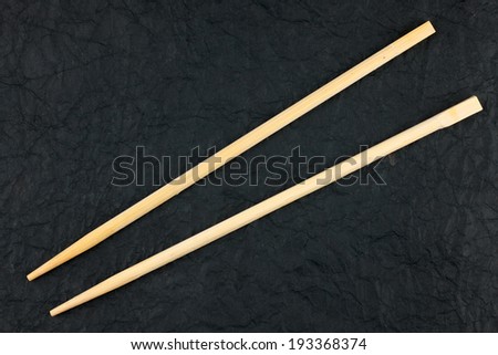 Chopsticks lay on a black napkin, can use as background