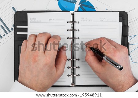Male hand with pen wrote in a diary, can be used as background
