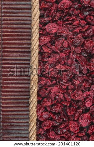 Dried cranberries lying on dark bamboo mat, for menu, can be used as background