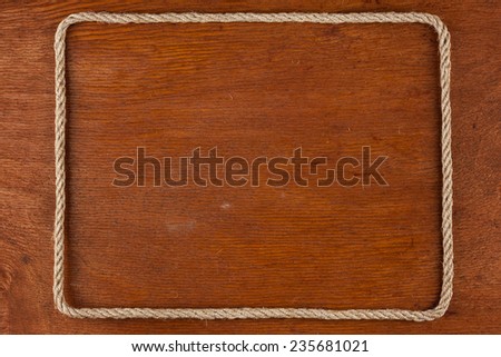 Frame of rope, lies on a background of a wooden surface, with place for your text