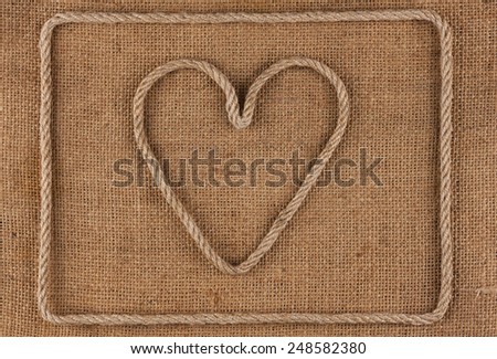 Heart made of rope on burlap, conceptual image