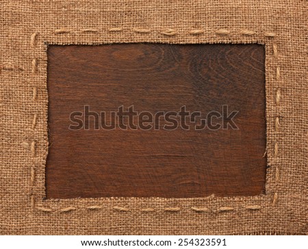 Frame of burlap, lies on a background of wood, with place for your text