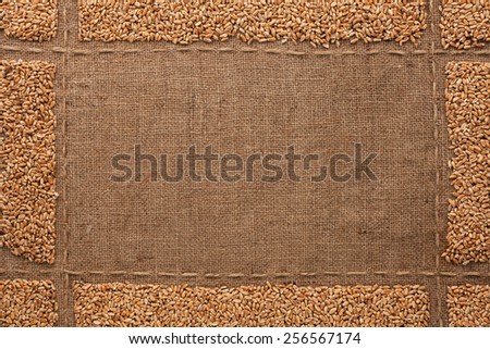 Beautiful frame with wheat grains on sackcloth, with place for your text, drawing