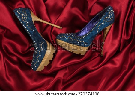 High-heeled shoes  lying on red  fabric, can use as background