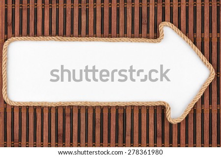 Pointer made of rope with a white background on the bamboo mat, with place for your text