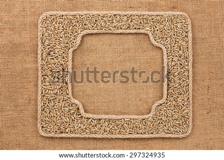 Two frames made of rope with rye  grains on sackcloth, as background, texture