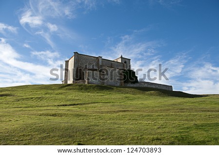 Church of San Martin de Atapuerca, in Burgos, Spain, on top of a hill with a blue background