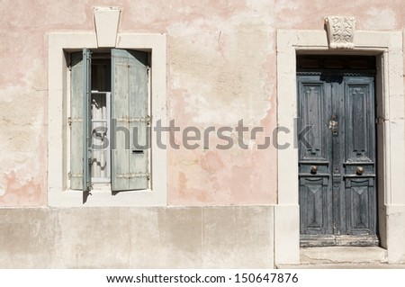 Blue wooden door and window in a pink facade of country house