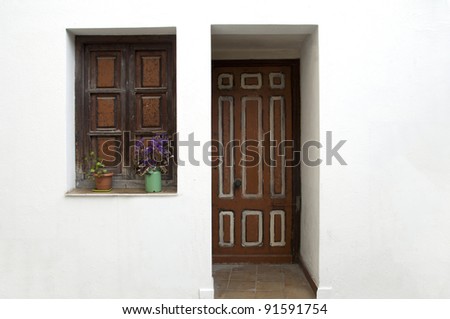 Wooden door and windows in a white facade of a house in Spain