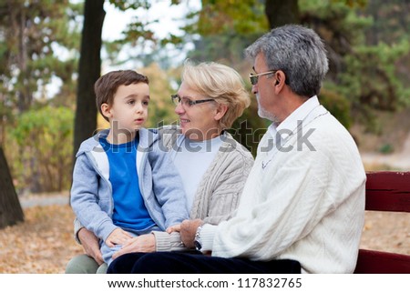 Grandma and Grandpa playing with grandson in the park, outdoors