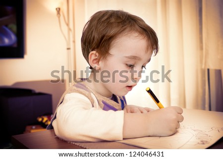 Boy writes, Preschool boy drawing on the table at home
