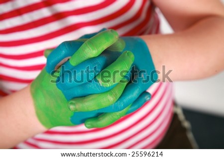 a young child with \'earth\' painted hands