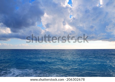 Dark heavy clouds and vast deep blue sea waters
