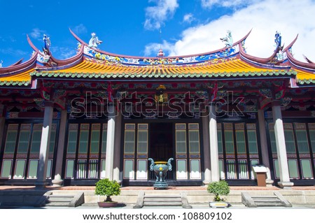 Taiwan Asian outdoor temple cultural totem carving wood yellow red white blue sky background Confucian temple