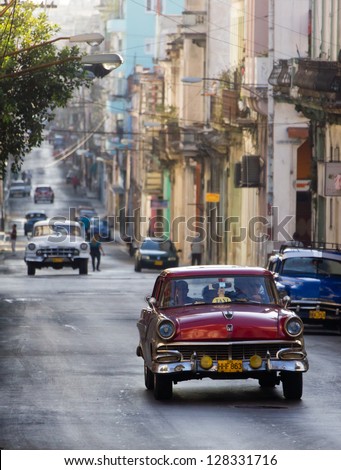 HAVANA JANUARY 15 Classic cars riding in a street on January 15 2013 in Havana These old and classic cars are an iconic sight of the island HAVANA JANUARY 15 Classic cars riding in a street on January 15 2013 in Havana These old and classic cars are an iconic sight of the island
