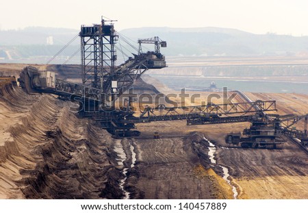 A very large bucket-wheel excavator and conveyor belt in a brown-coal mine