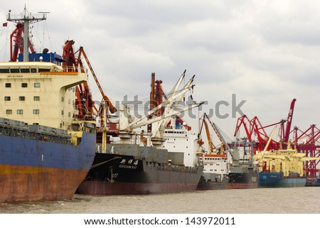 SHANGHAI - OCTOBER 3: A Ship unloading cargo on October 3, 2011 in Shanghai, China. Shanghai became the world\'s largest container port and plays a dominant role in the trade between East and West