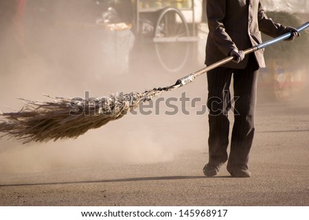 A woman sweeping a street (Xiahe, China)