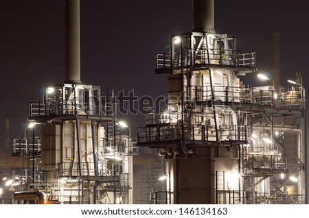 Close-up of pipes and tubes of a large oil-refinery plant at night
